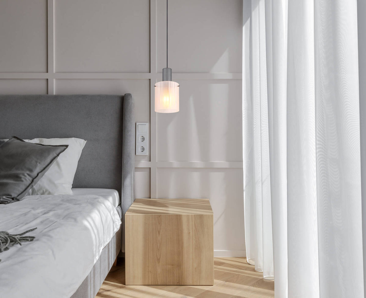 Mise en ambiance dans une chambre, suspension allumée près du lit