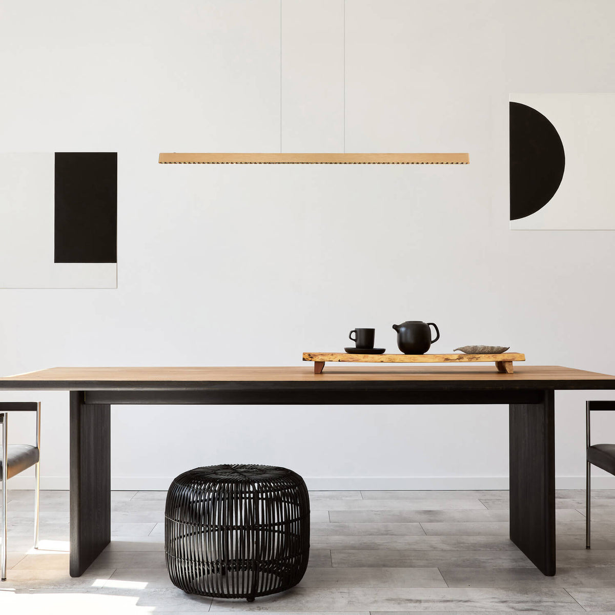 Mise en ambiance du luminaire suspendu au-dessus d'une table à manger en bois clair