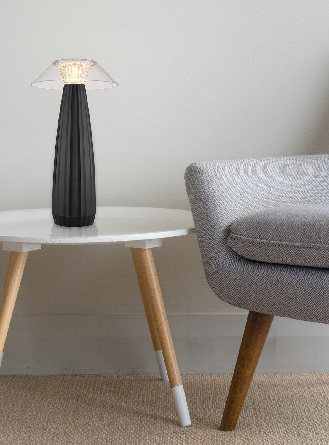 Mise en ambiance, lampe posée sur une table basse près d'un fauteuil gris