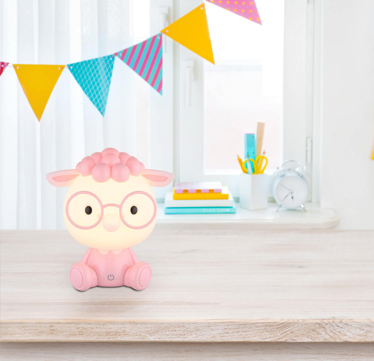 Mise en ambiance sur un bureau d'enfant, lampe mouton allumée près d'une fenêtre