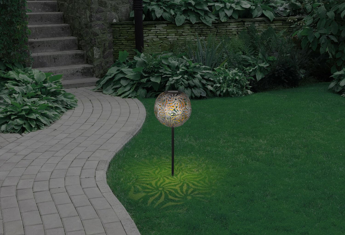 Mise en ambiance nocturne dans un jardin, ombres fleuries projetées sur la pelouse.