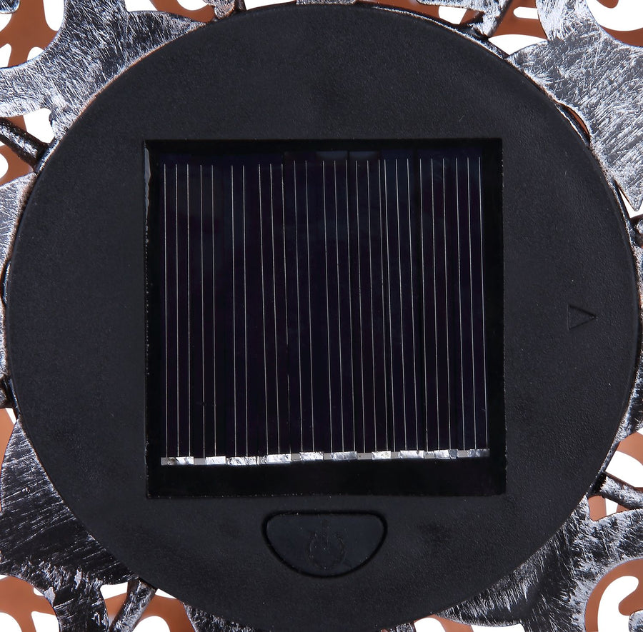 Détail du panneau solaire noir et du bouton au sommet du luminaire extérieur.