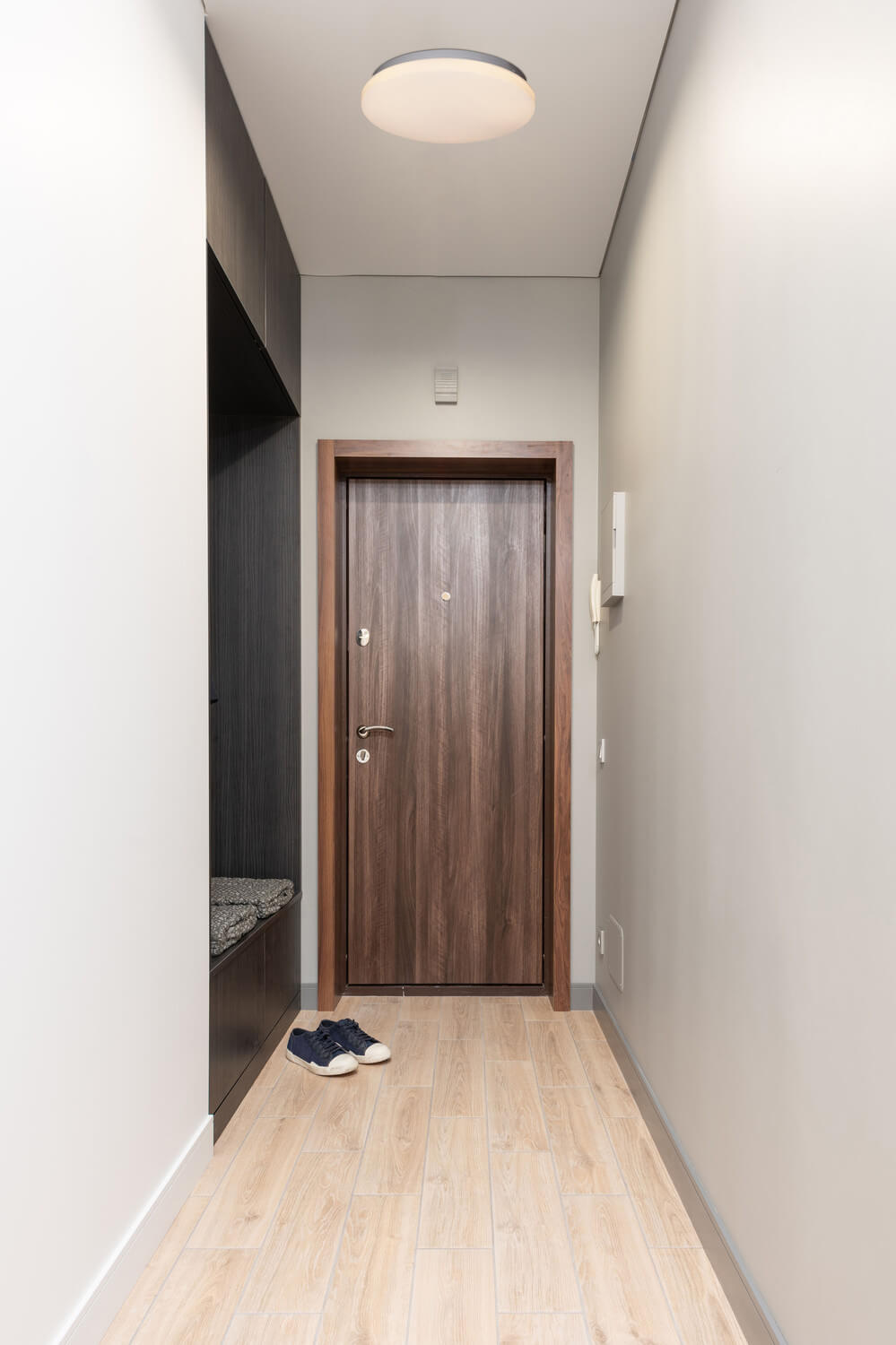 Mise en ambiance du plafonnier allumé dans un couloir d'entrée moderne aux murs clairs