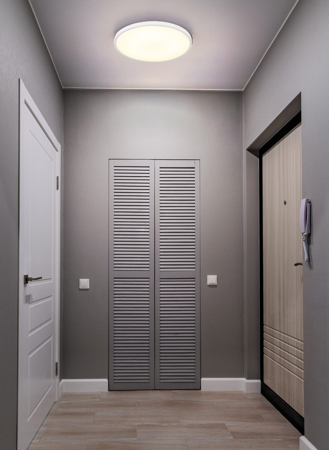 Mise en ambiance du plafonnier installé au plafond d'un couloir gris contemporain