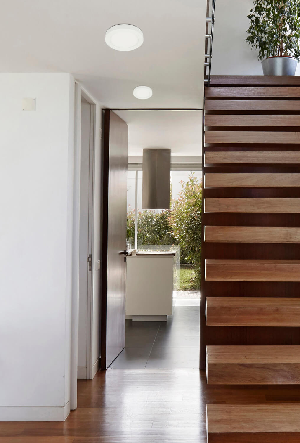Mise en ambiance dans un couloir, deux plafonniers blancs au plafond près d'un escalier