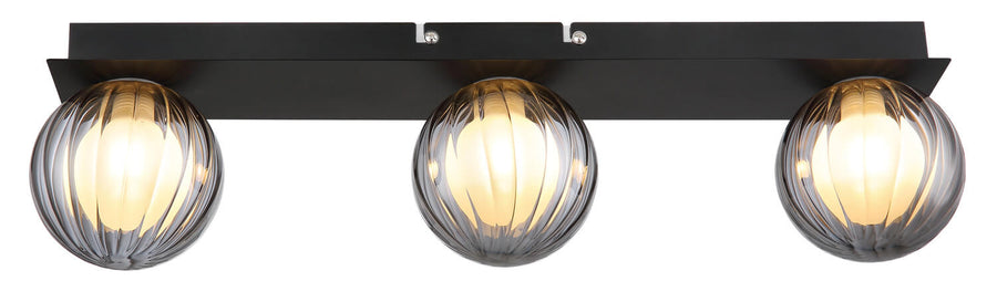 Vue de face du plafonnier allumé avec ses trois globes en verre strié.
