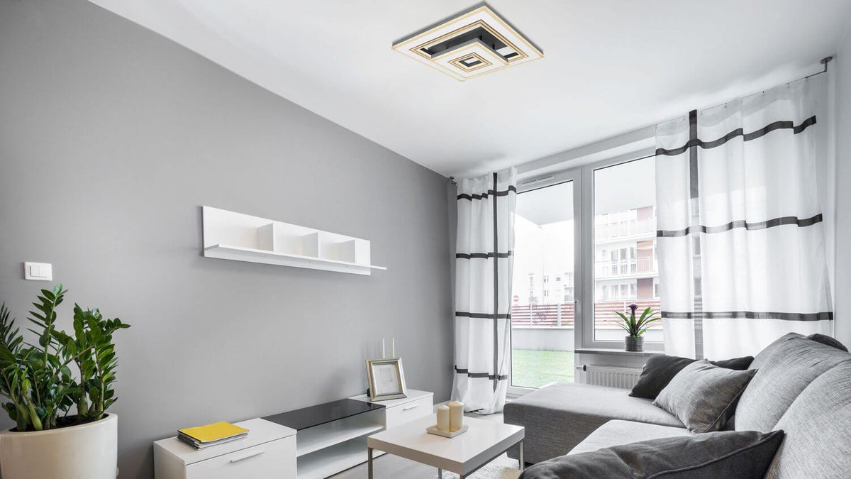 Plafonnier carré installé au plafond dans un salon contemporain gris et blanc.