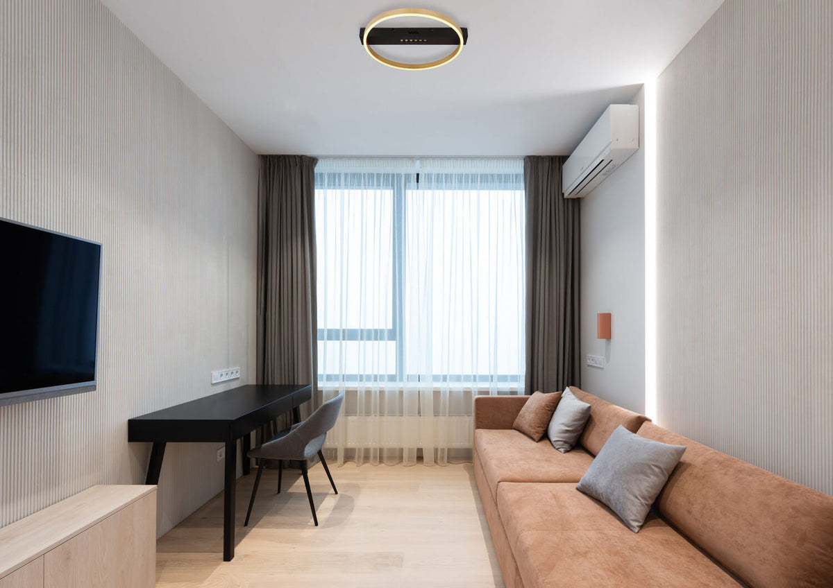Mise en ambiance du plafonnier allumé dans un salon au plafond blanc.