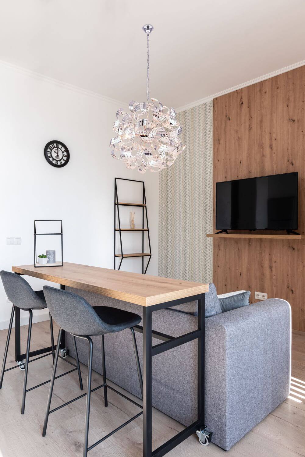 Mise en ambiance du luminaire suspendu au-dessus d'une table haute dans un séjour moderne