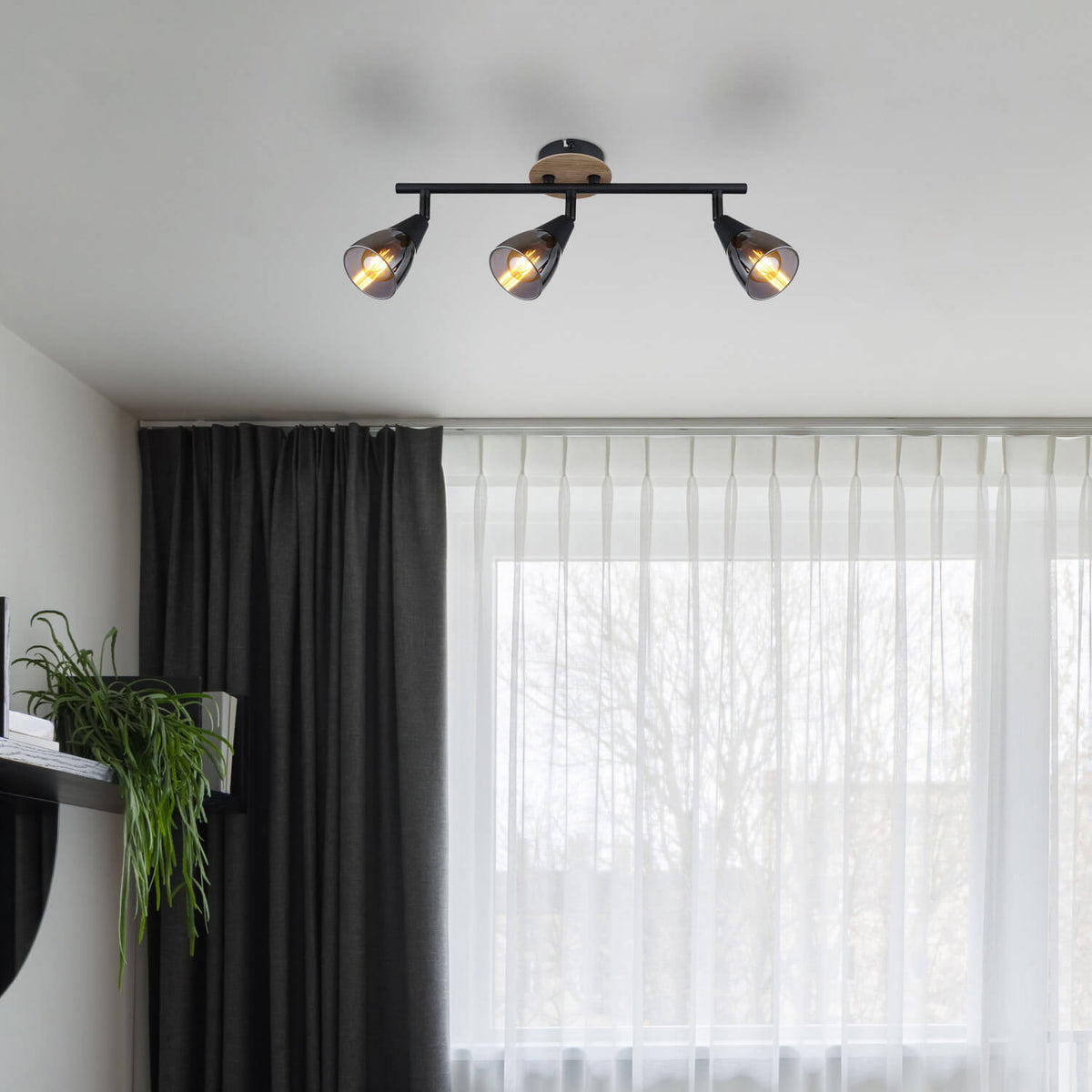 Mise en ambiance du luminaire fixé au plafond devant une fenêtre avec rideaux.