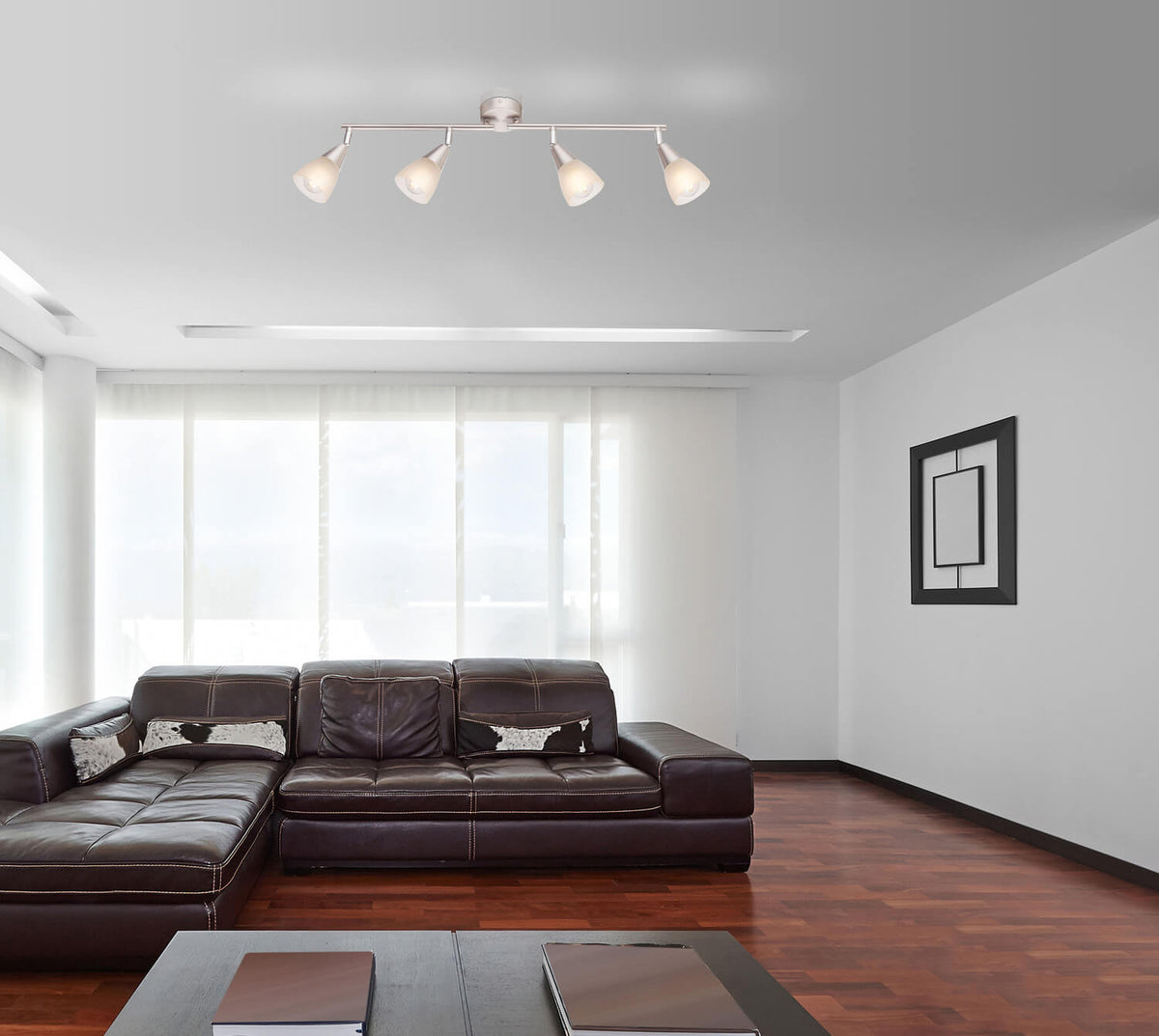 Mise en ambiance du plafonnier allumé dans un salon au mobilier contemporain et canapé en cuir.
