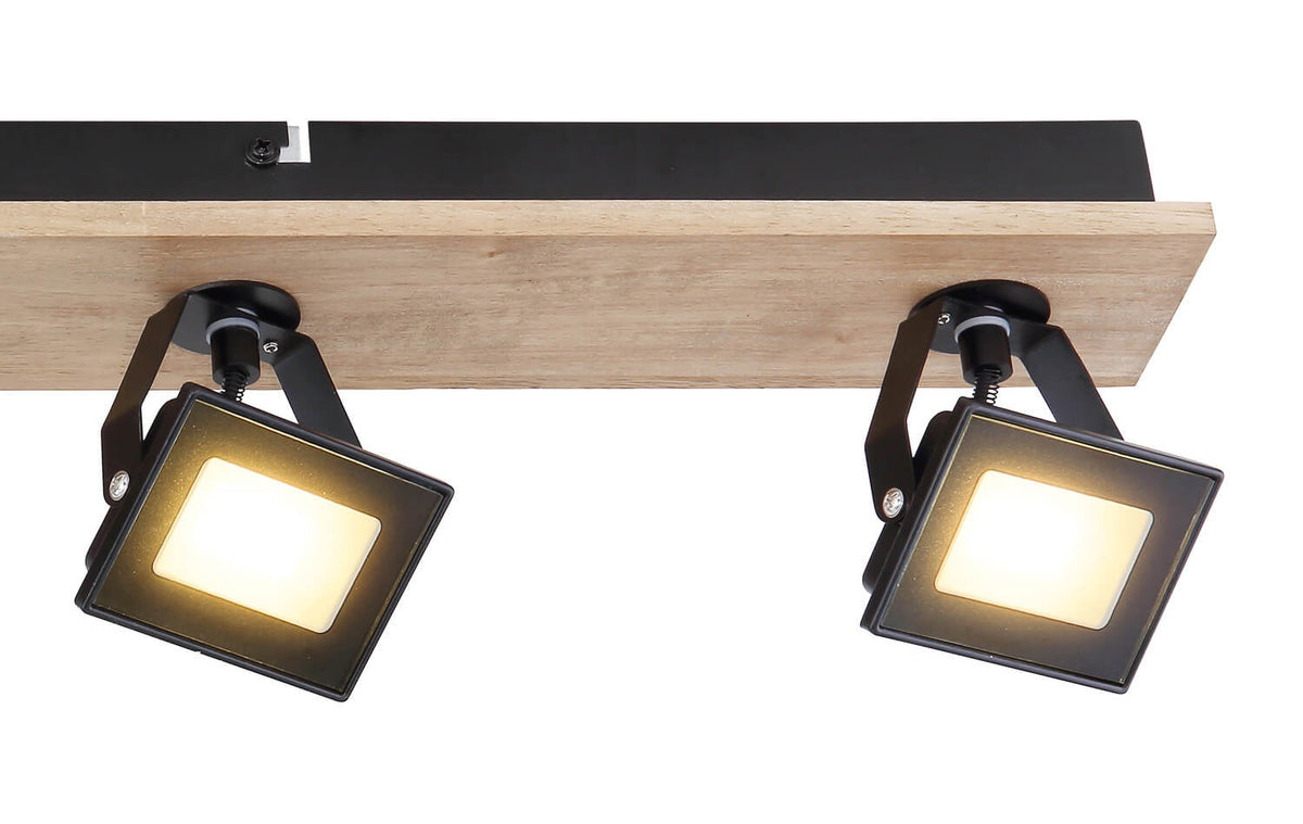 Gros plan sur deux spots allumés montrant le support métallique et la base en bois.