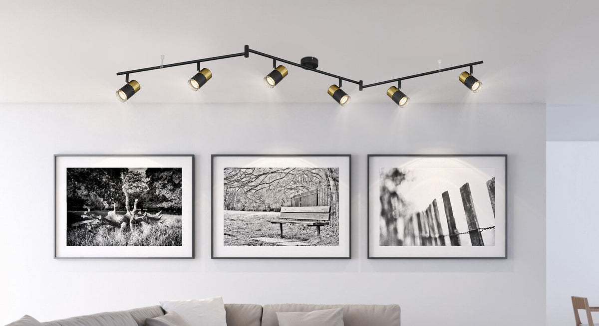 Mise en ambiance au-dessus de trois cadres, le luminaire éclaire le mur.