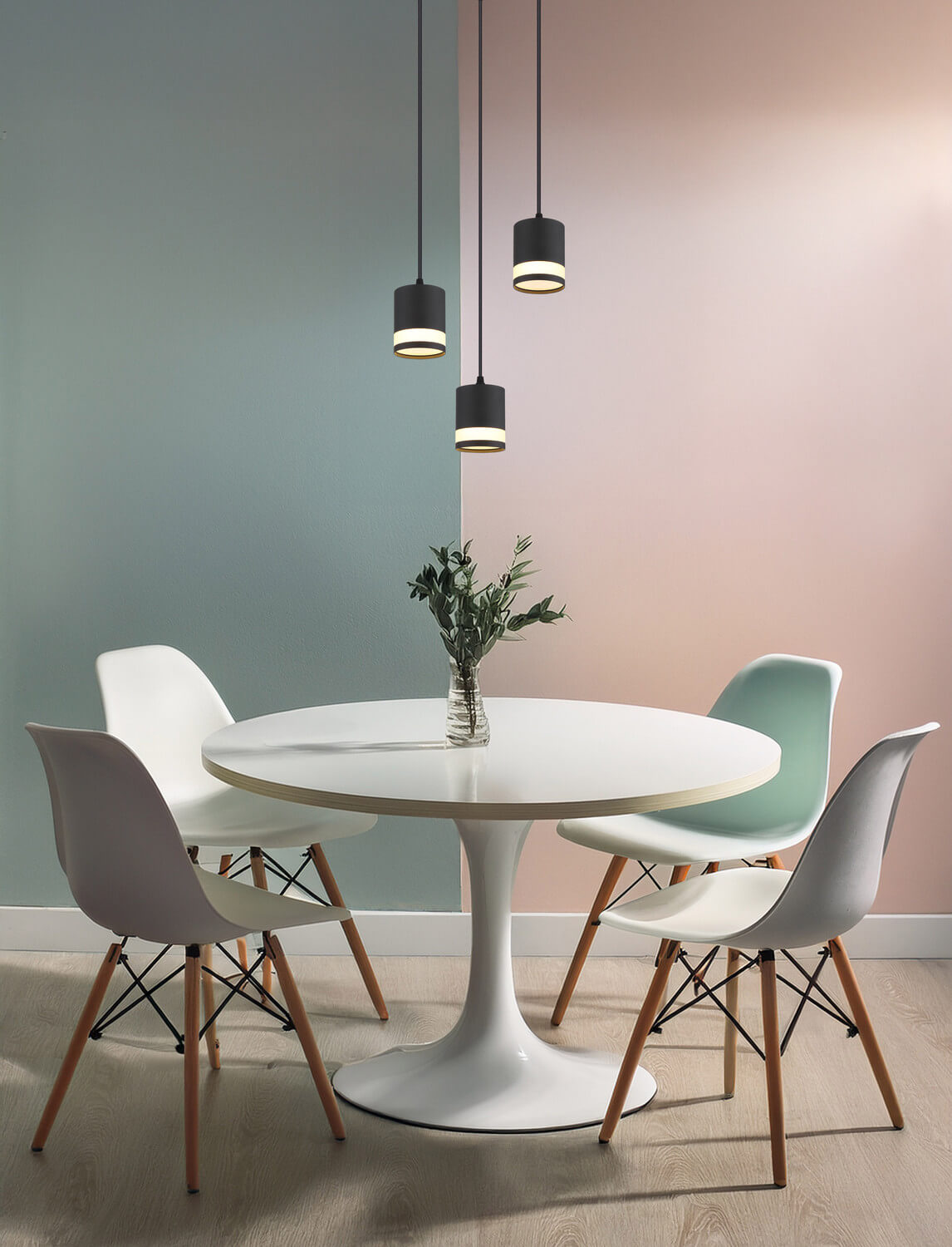 Mise en ambiance au-dessus d'une table ronde, suspension allumée dans une pièce colorée.