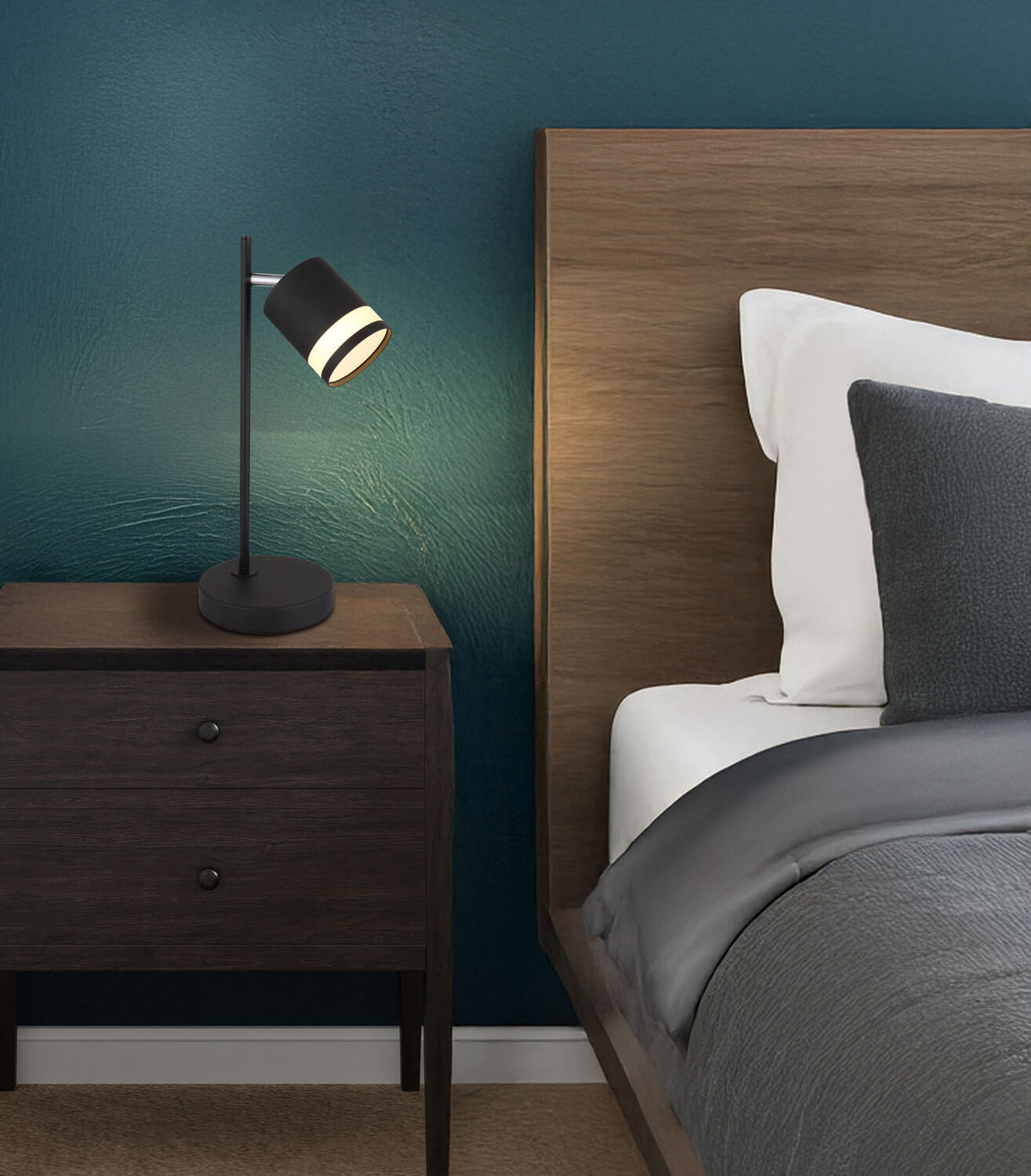 Mise en ambiance sur une table de nuit en bois, tête de lit bleu nuit