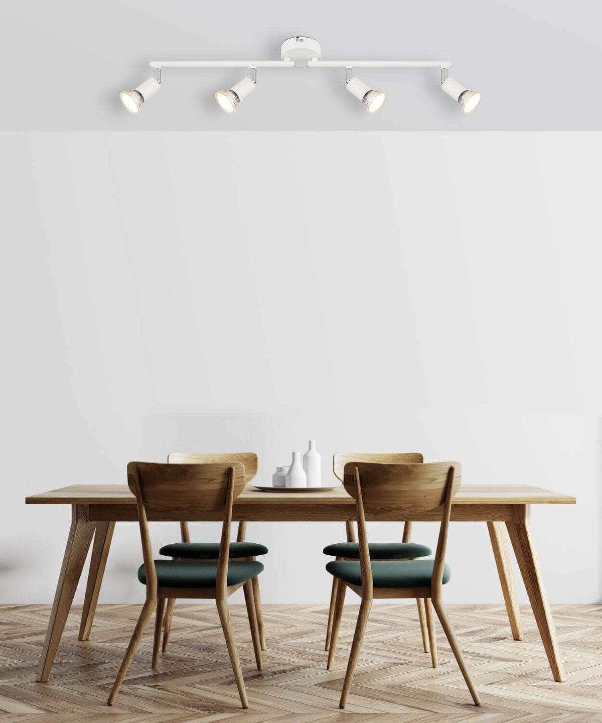 Luminaire blanc installé au plafond au-dessus d'une table en bois et chaises vertes