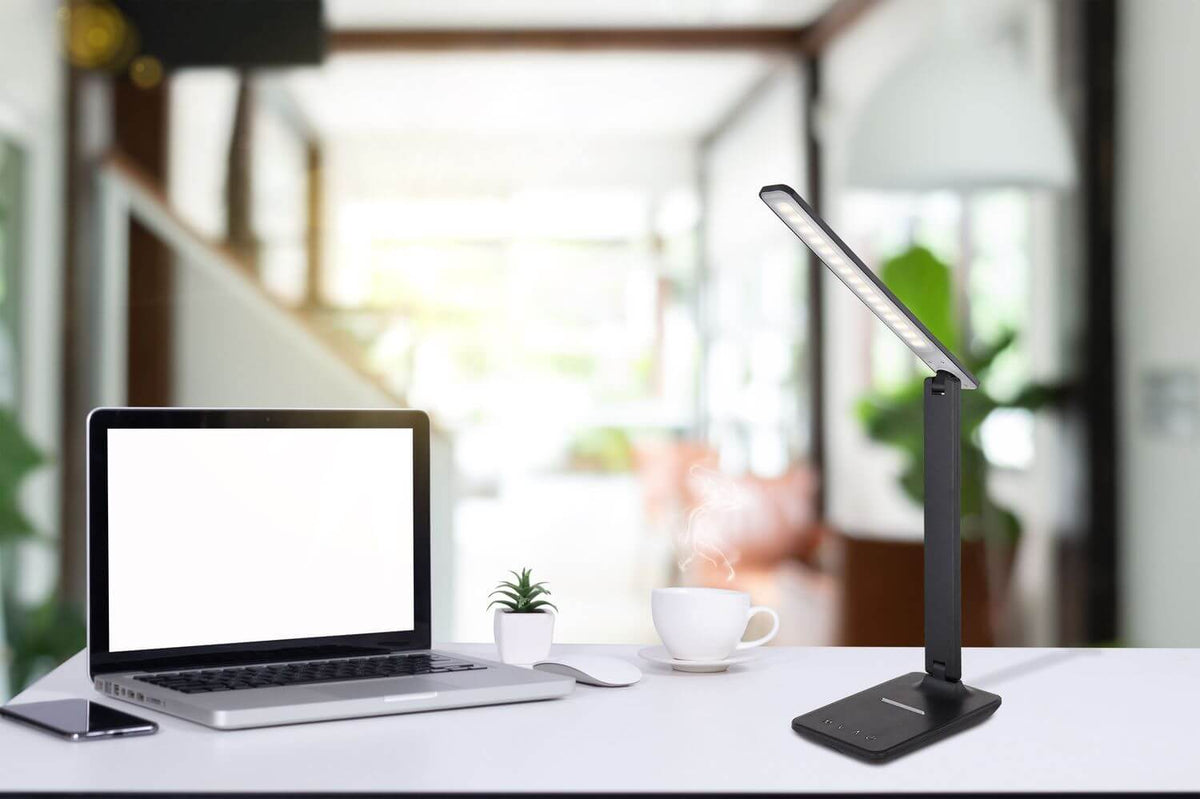 Mise en ambiance sur un bureau avec ordinateur portable, tasse et plante verte