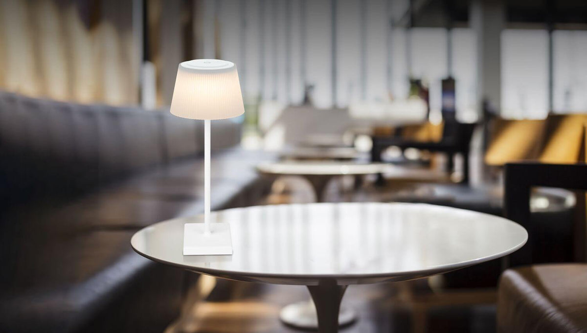 Lampe blanche allumée posée sur une table dans un salon contemporain