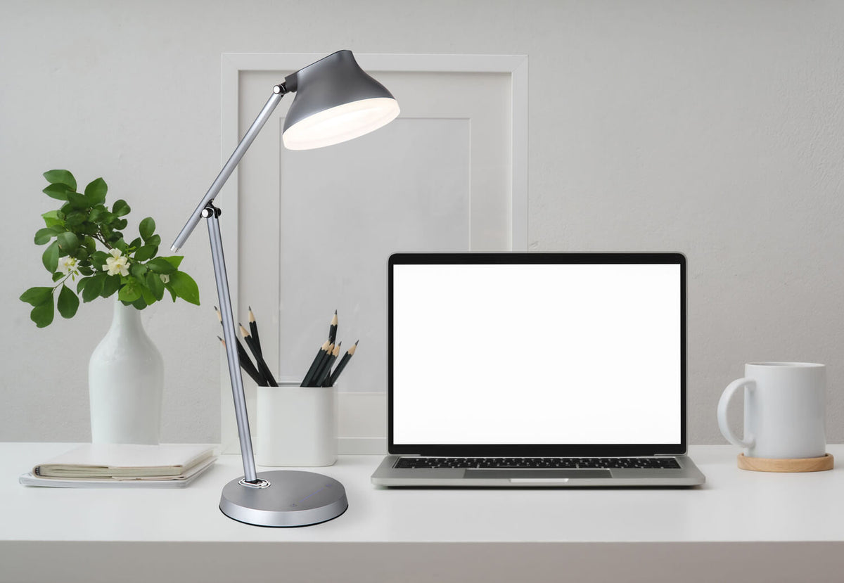 Mise en ambiance sur un bureau blanc avec ordinateur portable, plante et mug