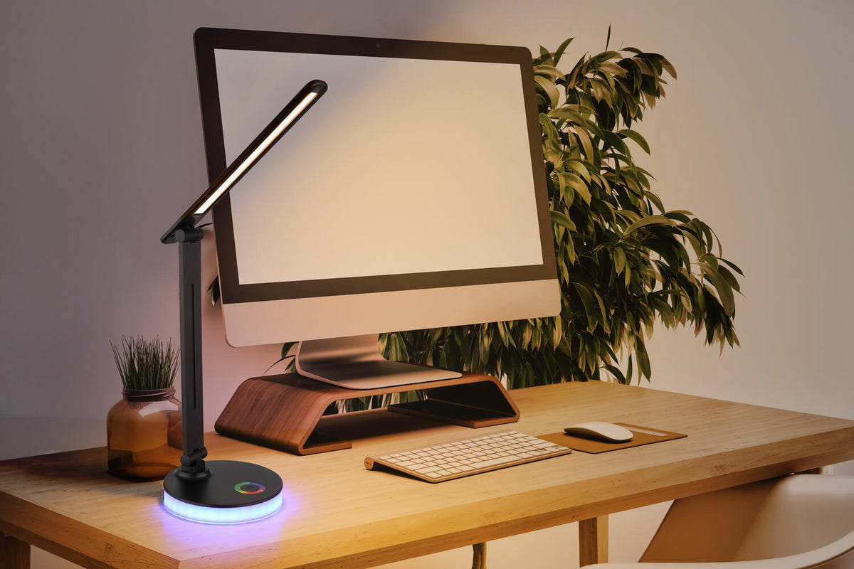 Mise en ambiance sur un bureau en bois, près d'un écran et d'une plante