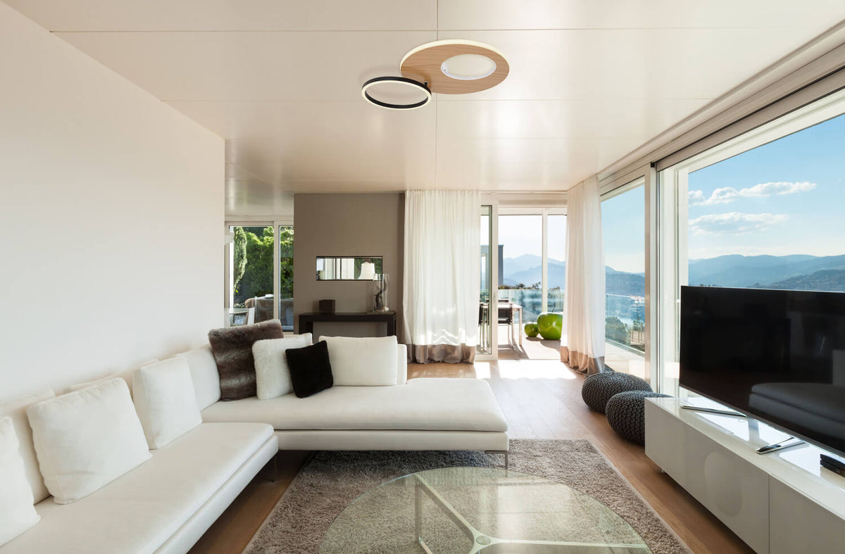 Mise en ambiance dans un salon contemporain, plafonnier allumé fixé au plafond blanc