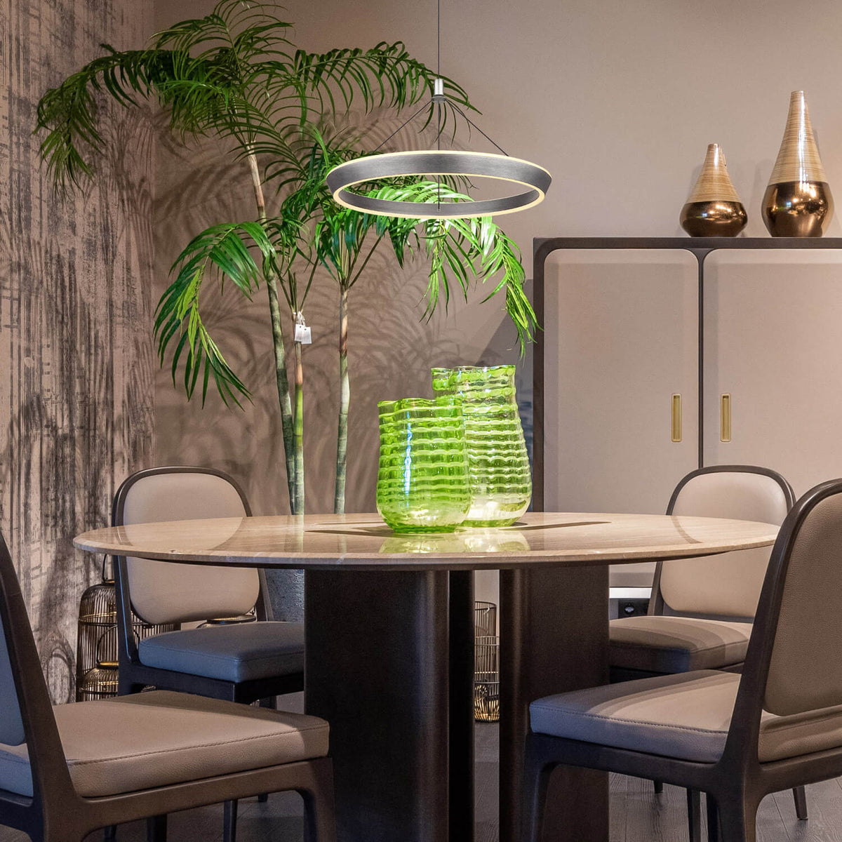 Mise en ambiance : suspension allumée au-dessus d'une table ronde meublée