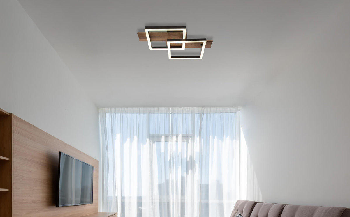 Mise en ambiance du plafonnier allumé dans un salon moderne avec canapé