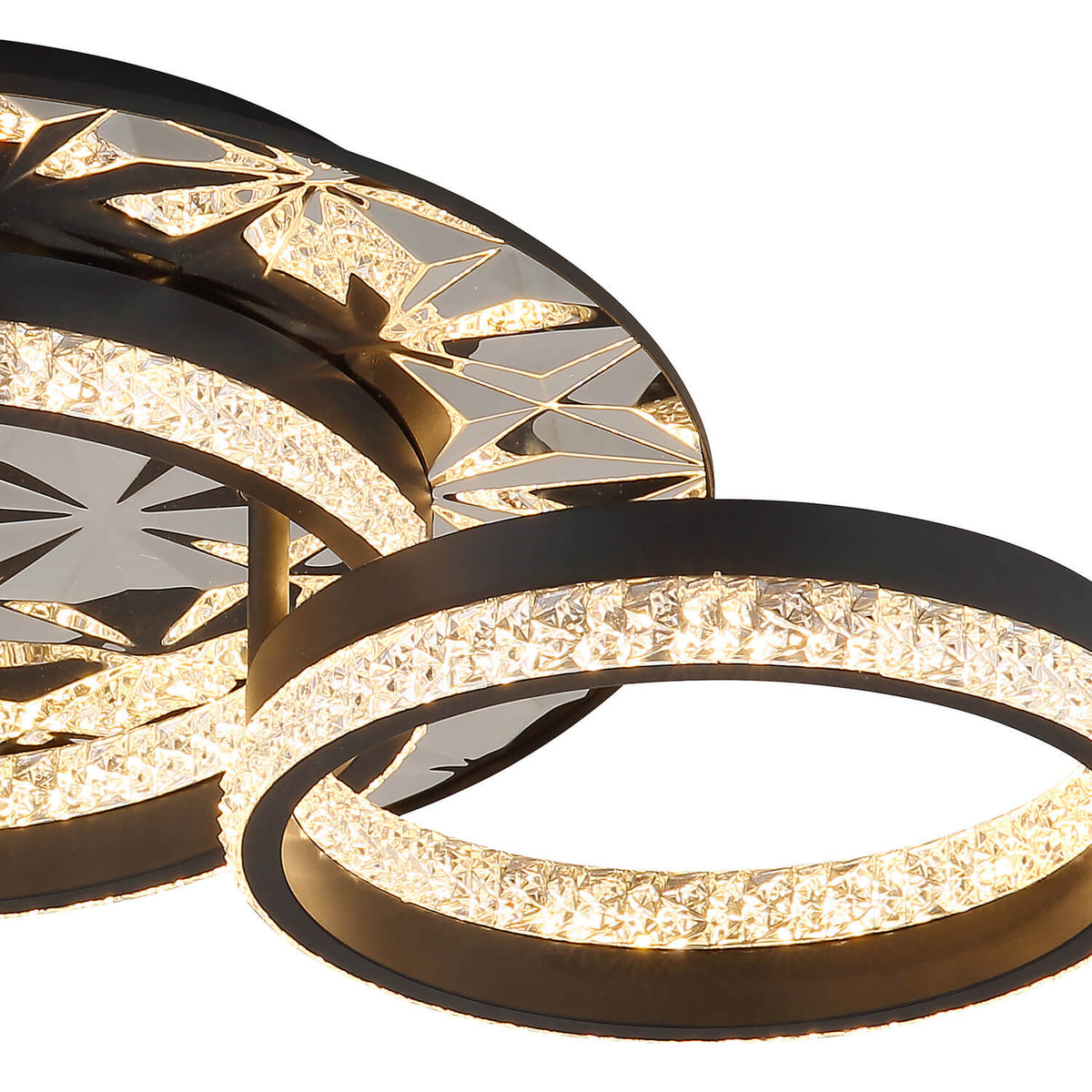 Gros plan sur la bague en cristal illuminée et la structure métallique noire du luminaire.