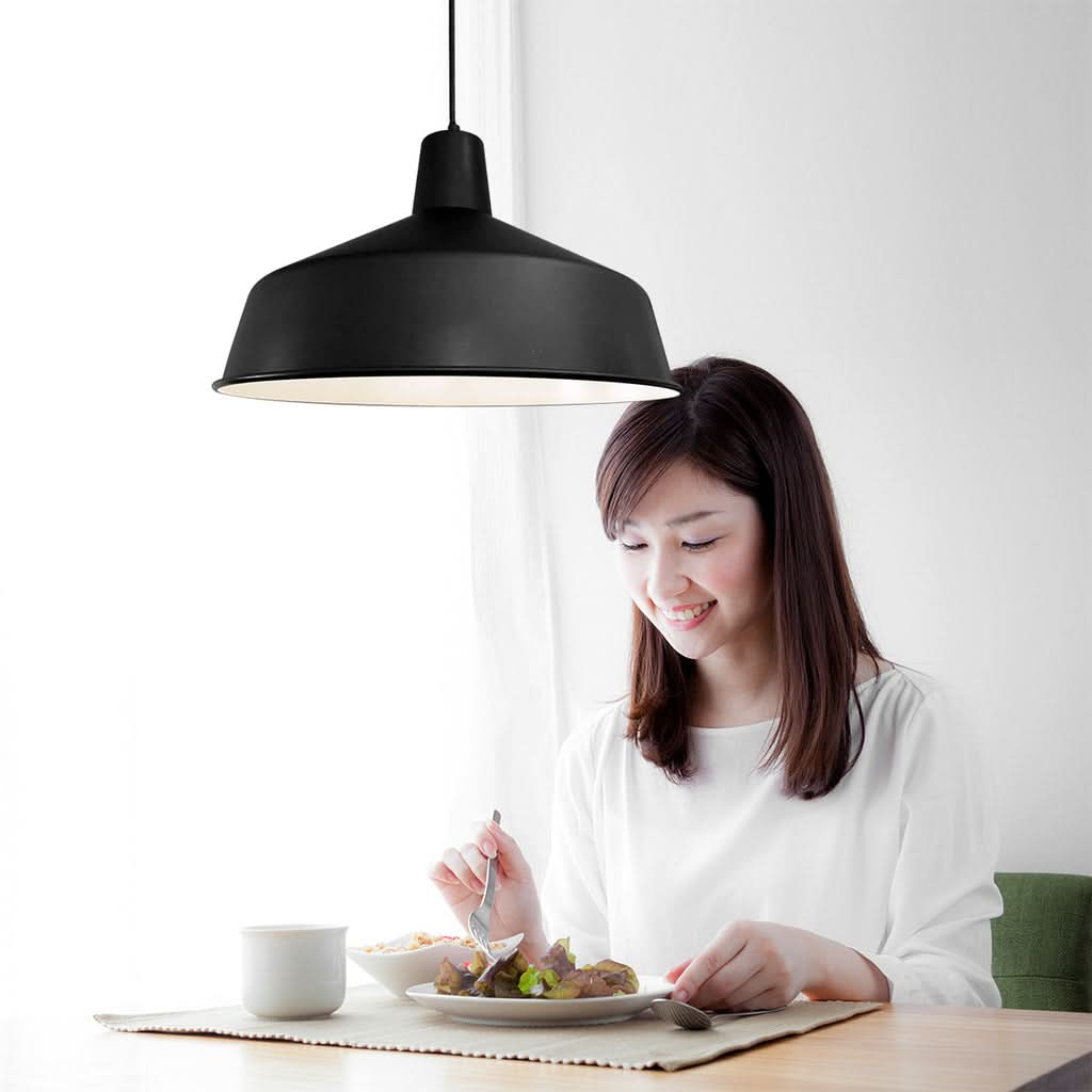 Suspension industrielle noire au-dessus d'une table dans une cuisine | Designix