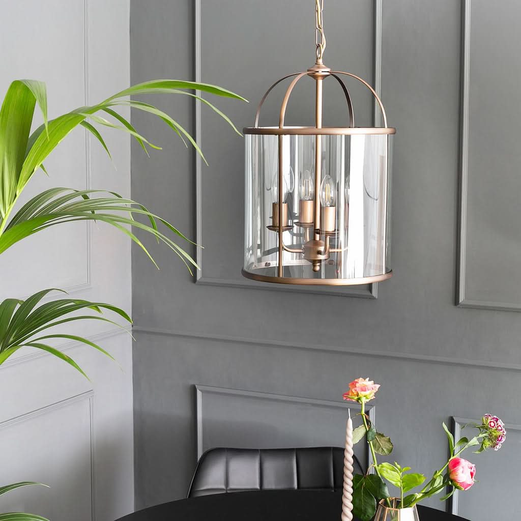 Suspension lanterne bronze en verre clair au-dessus d'une console d'entrée, style classique