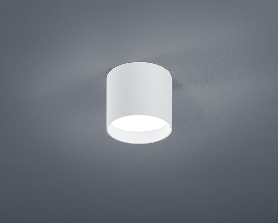 Plafonnier blanc cylindrique fixé au plafond, vue de face sur fond gris