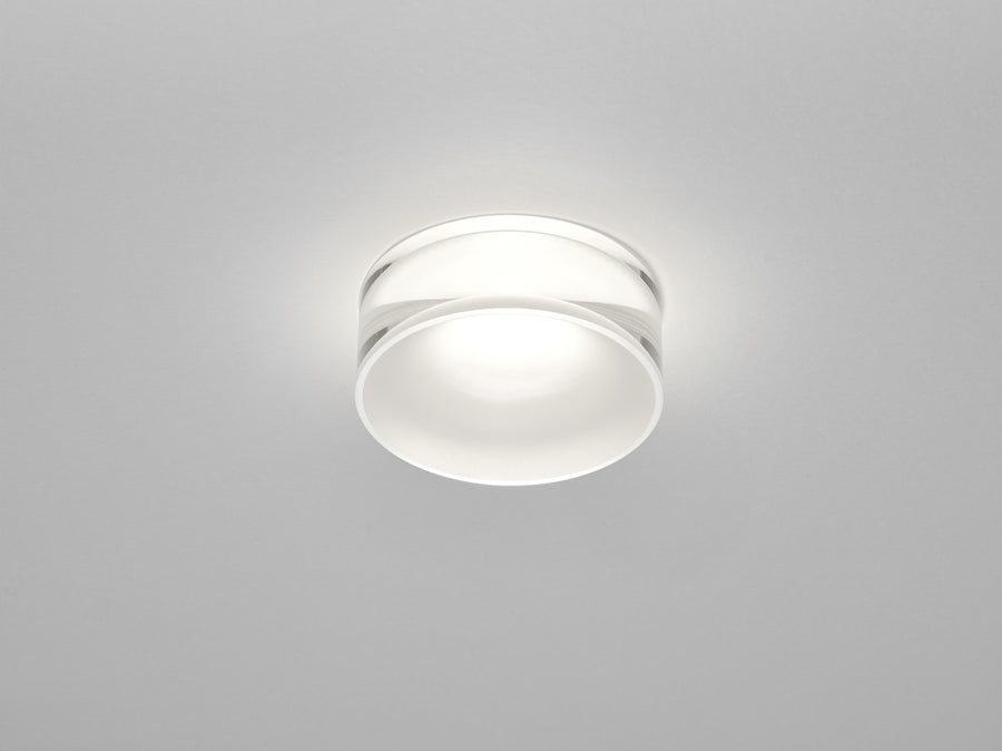 Luminaire rond blanc vue de face sur fond gris, diffuseur opale allumé