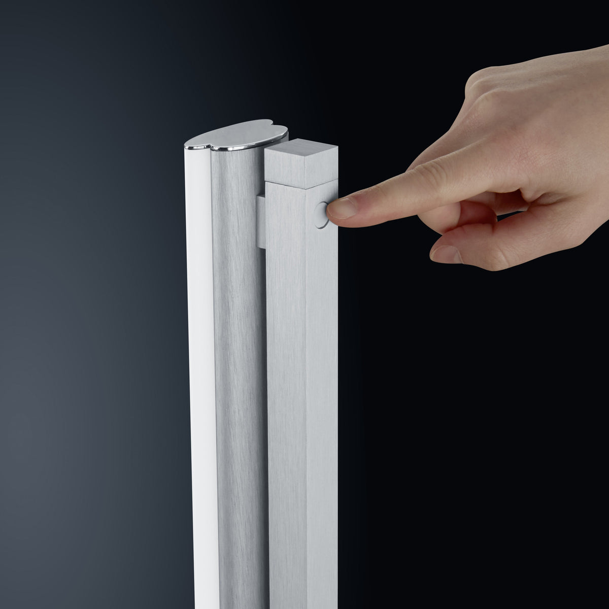 Gros plan sur le haut du montant, doigt actionnant le bouton variateur tactile en aluminium.