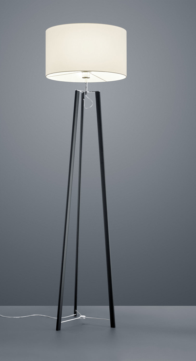 Vue rapprochée du lampadaire noir, abat-jour blanc et piétement tripode élancé