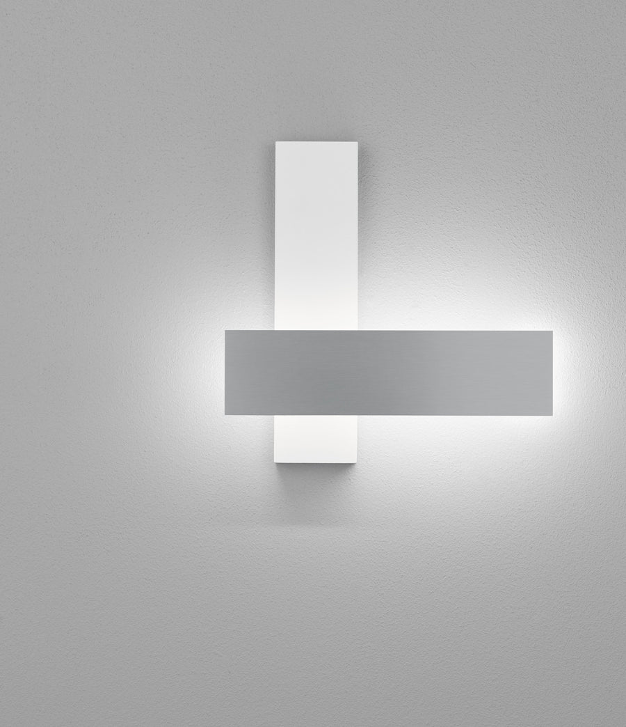 Vue frontale de l'applique allumée, halo lumineux diffus autour des plaques d'aluminium blanc