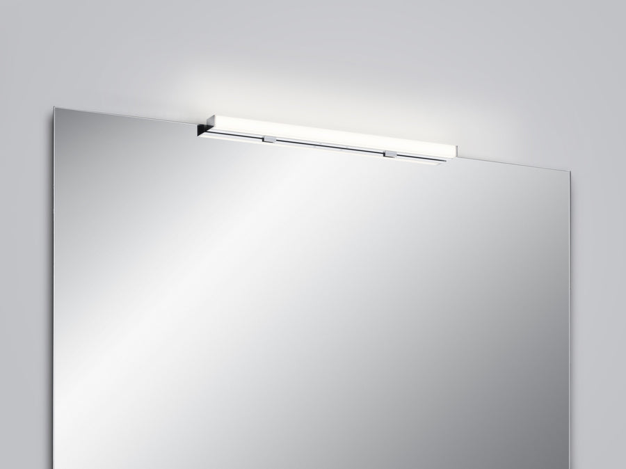 Applique chromée horizontale fixée au-dessus d'un miroir de salle de bain, éclairage diffus.