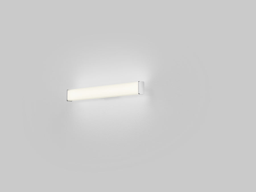 Vue de face allumée sur mur blanc, halo lumineux diffus et applique fine horizontale.