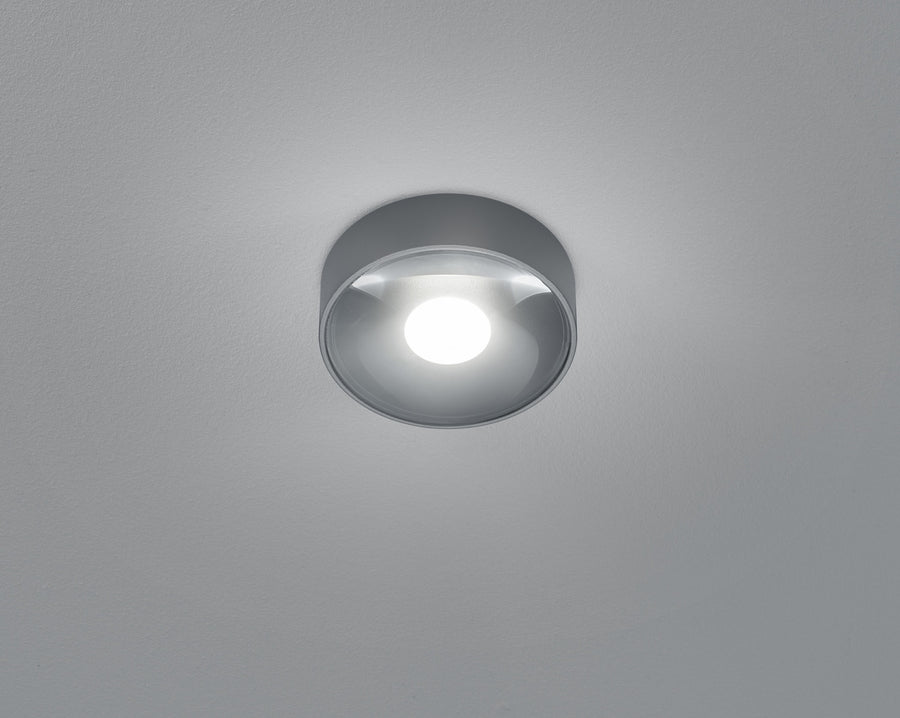 Vue rapprochée par dessous du plafonnier allumé, verre bombé et lumière blanche