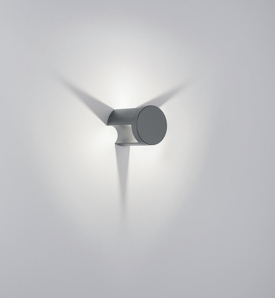 Profil rapproché de l'applique murale cylindrique grise avec faisceau lumineux