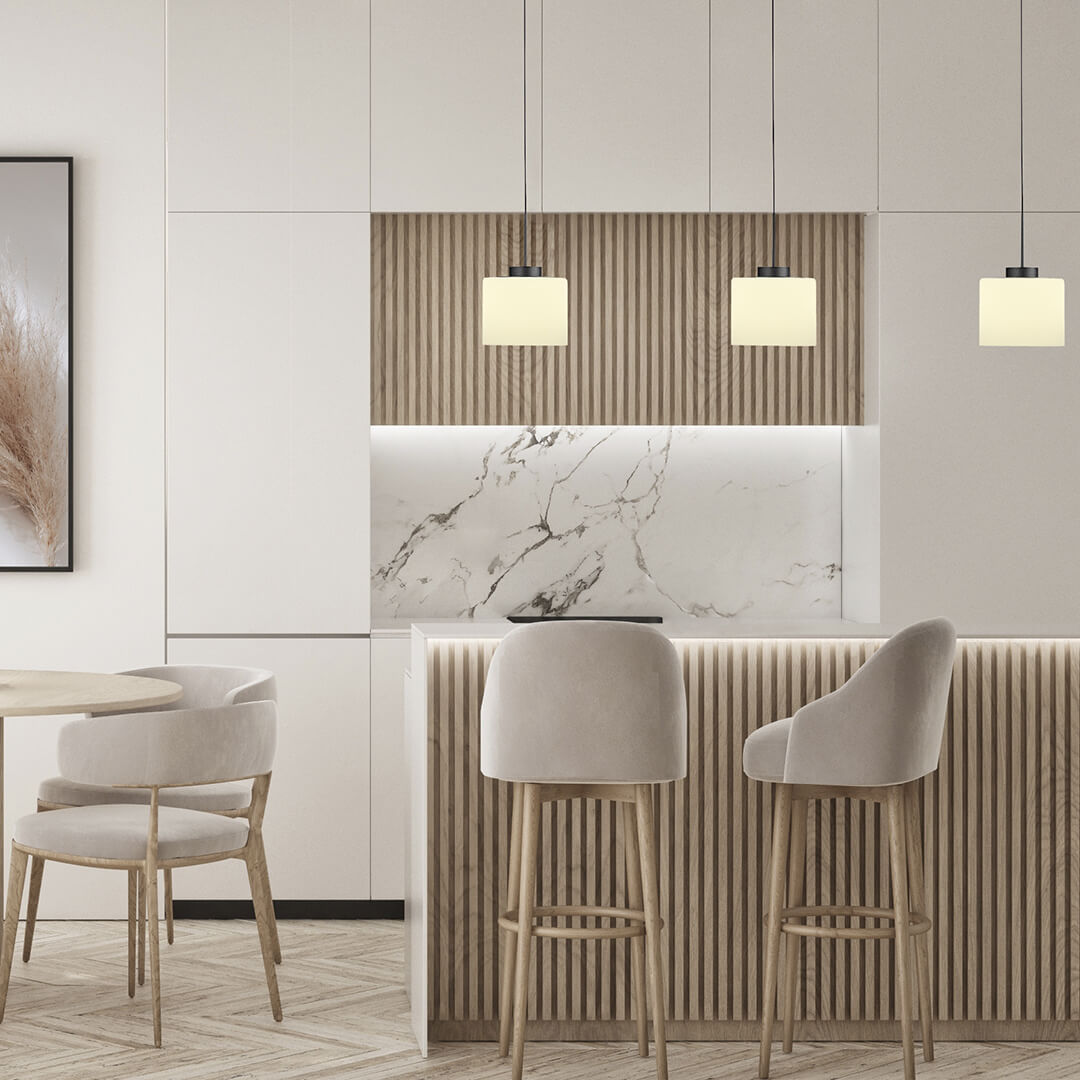 Mise en ambiance dans une cuisine moderne, suspension allumée au-dessus d'un comptoir et tabourets