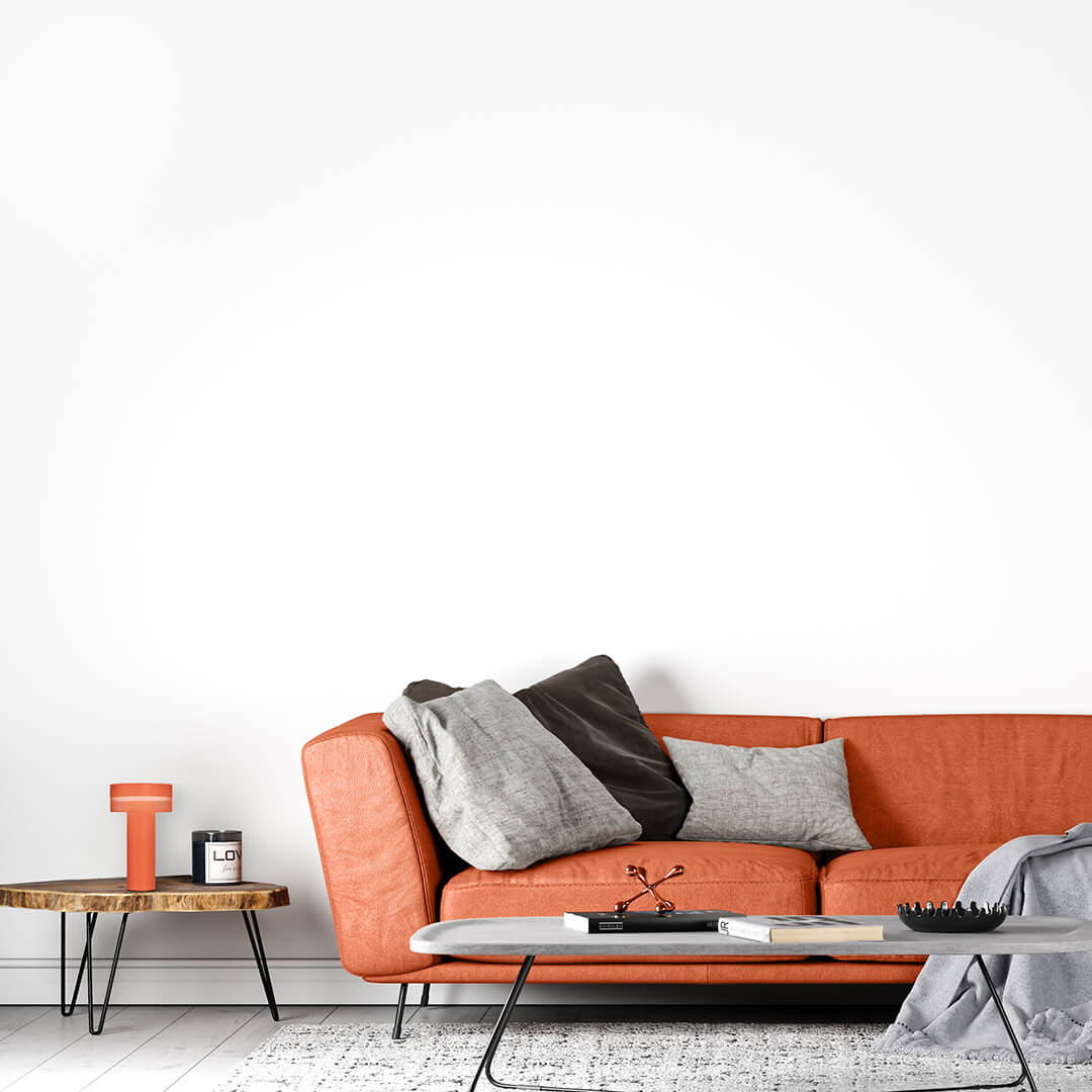 Mise en ambiance, lampe orange sans fil posée sur une table en bois près d'un canapé