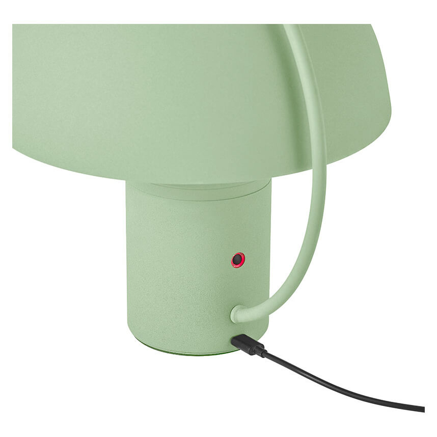 Détail du pied cylindrique vert avec bouton rouge et câble d'alimentation noir