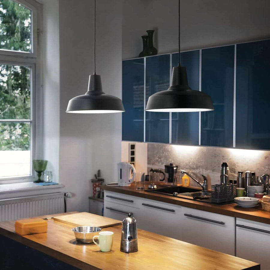 Deux suspensions noires allumées au-dessus d'un plan de travail de cuisine