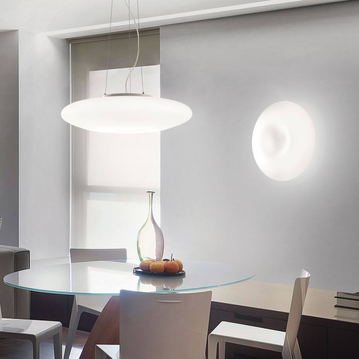 Mise en ambiance : luminaire suspendu au-dessus d'une table à manger en verre