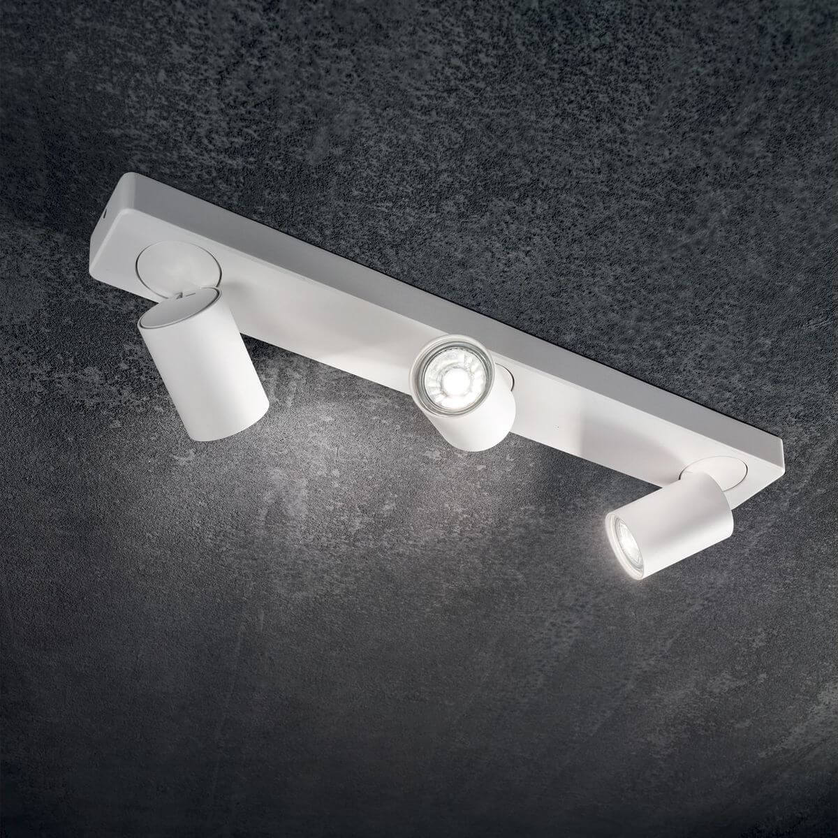 Mise en ambiance sombre montrant le plafonnier blanc allumé avec spots orientables.