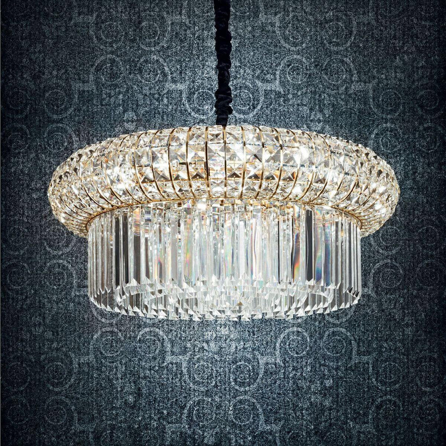 Gros plan du luminaire illuminé devant papier peint à motifs, reflets irisés des facettes