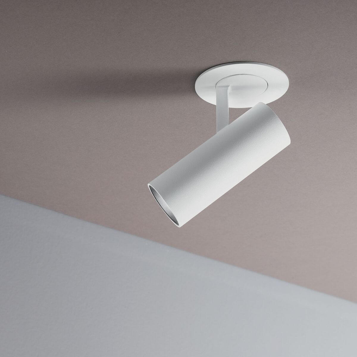 Gros plan sur la finition mate blanche du projecteur orientable sous plafond beige