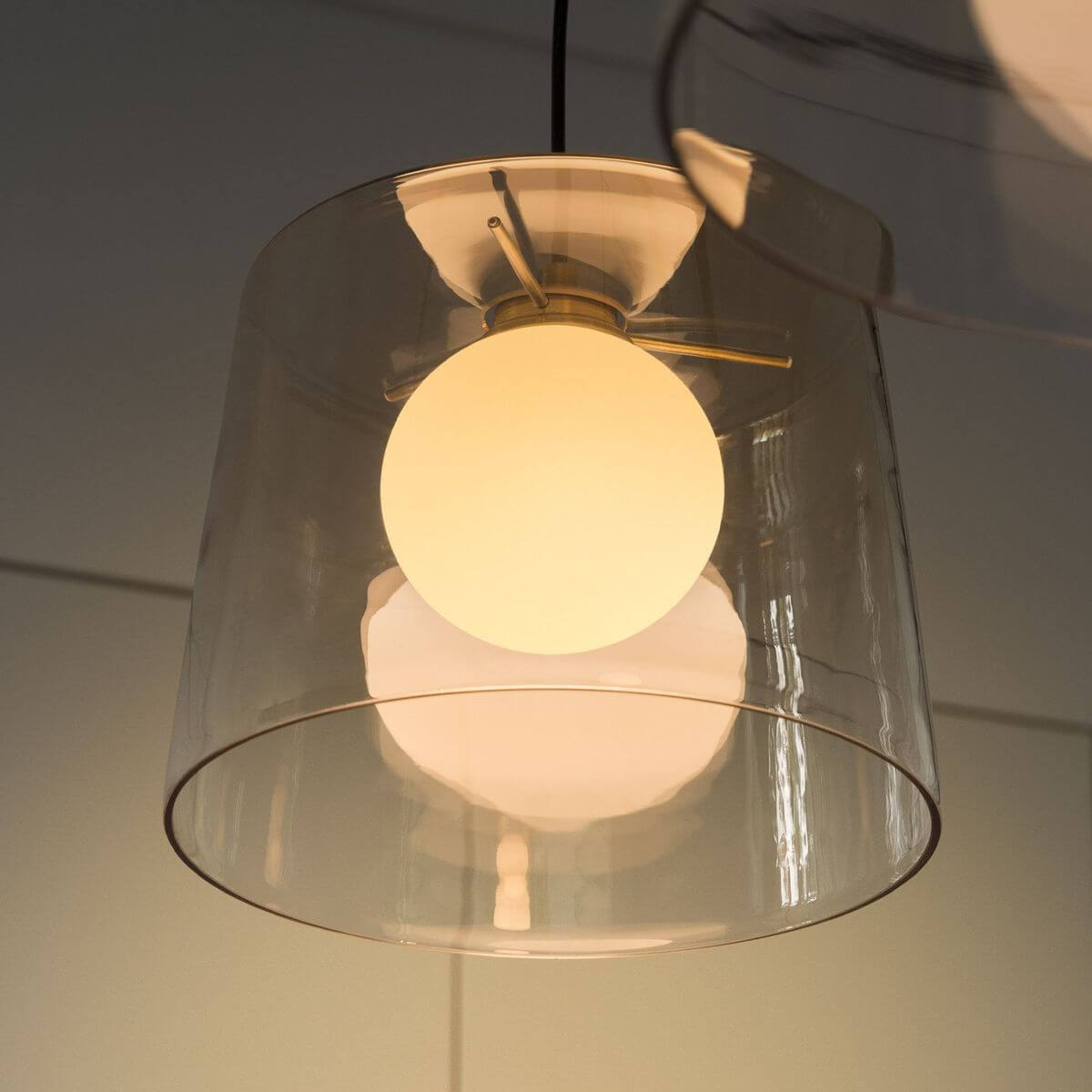 Gros plan en contre-plongée sur l'abat-jour transparent et la sphère lumineuse
