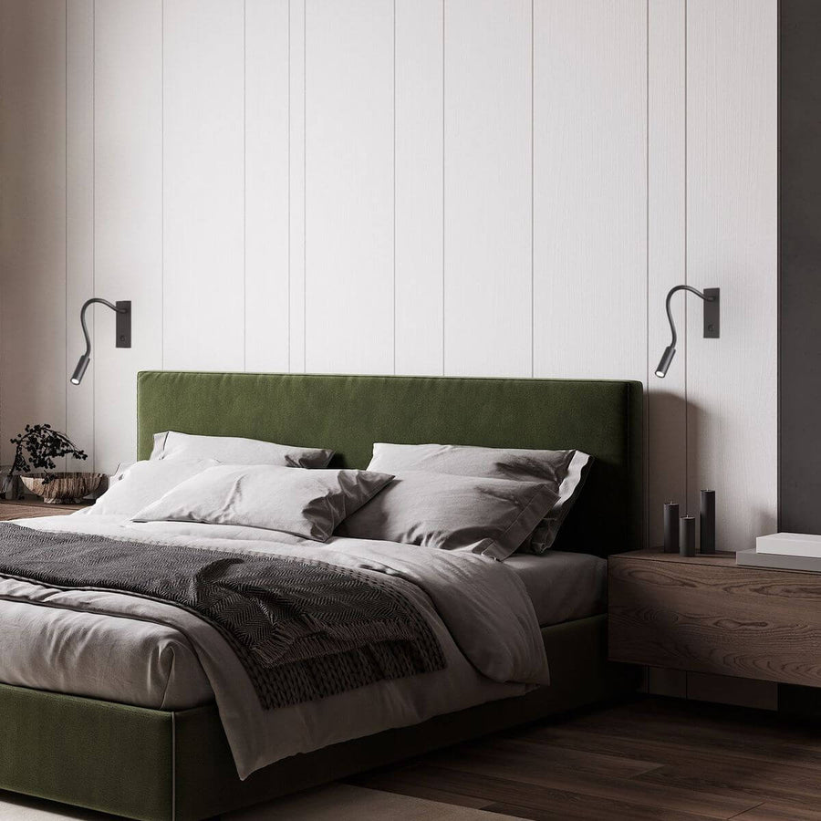 Deux appliques noires de part et d'autre d'un lit à tête verte, en situation