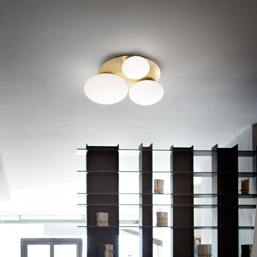 Luminaire allumé fixé au plafond au-dessus d'une bibliothèque sombre